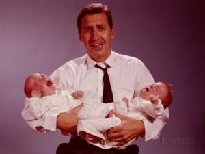 h-armstrong-roberts-distressed-looking-father-holding-crying-twin-babies-in-his-arms